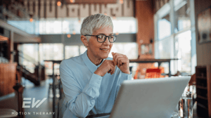 An older woman looks at her computer.