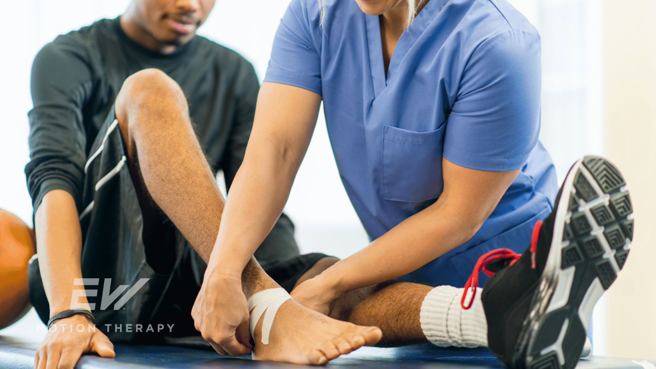 A female nurse wraps a man's ankle with kinesiology tape.