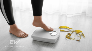 Close-up of two feet stepping on a scale.