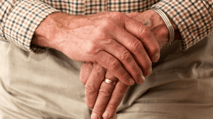 Close-up of an old man's hands holding a cane