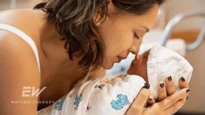 A woman puts her nose to the nose of her newborn baby.