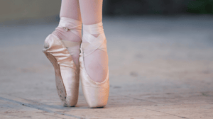 A close-up of a ballet dancer's feet in pointe shoes.