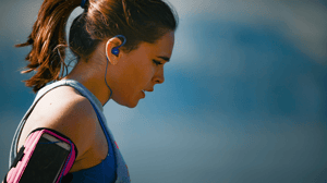From the side, a woman pauses her run to take a breath