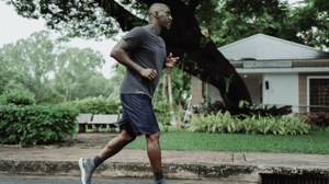 A man jogs in a neighborhood