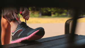 Tying a shoe propped on a bench.