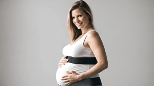 A pregnant woman wearing a support band around her waist
