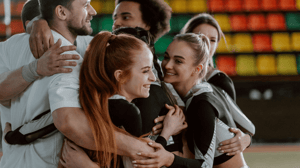 A group of cheerleaders smile and hug.