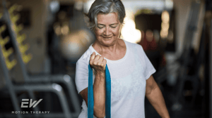 An older woman pulls a resistance band.