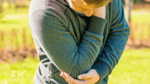 A man grips his elbow in pain.
