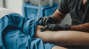 A doctor examines the back of a man's knee.