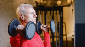 An older man lifts weights.