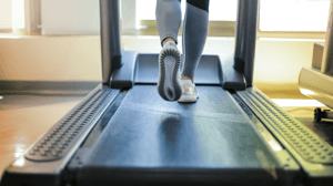 From behind, feet run on a treadmill