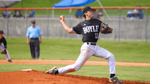 A baseball pitcher winds up to throw.