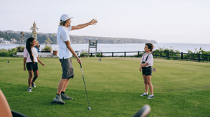 Kids on a golf course with a pro