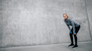 A woman taking a break from her run to catch her breath